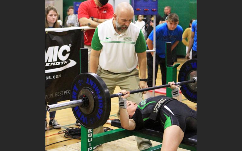 Suwannee assistant coach Dan Marsee watches as his daughter Matti Marsee bench presses during the Class 1A state meet on Friday. Marsee won the state title in the 110 class. (PAUL BUCHANAN/Special to the Reporter)