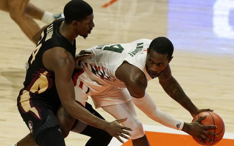 Miami guard Elijah Olaniyi (4) looks to pass the ball as Florida State guard Sardaar Calhoun (24) defends on Wednesday in Coral Gables. (MARTA LAVANDIER/Associated Press)