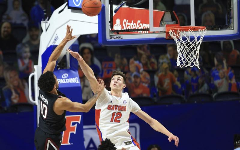South Carolina forward Justin Minaya (10) makes a shot over Florida forward Colin Castleton (12) during the first half Wednesday in Gainesville. (MATT STAMEY/Associated Press)