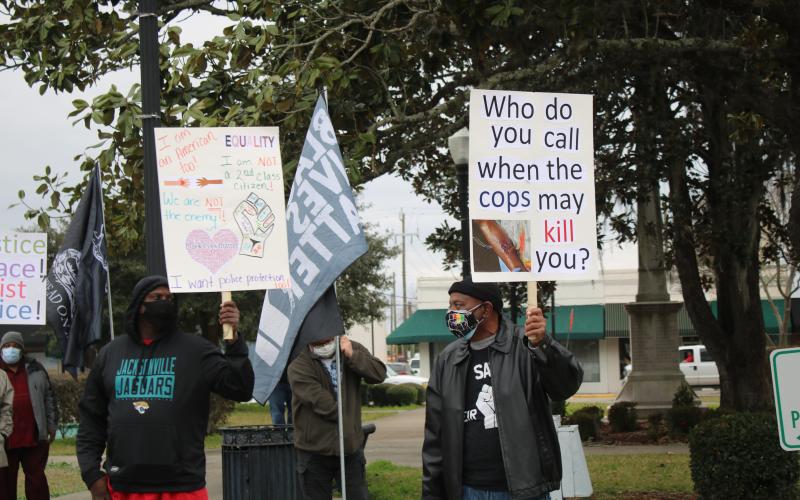 Protesters, including Glenel Bowden (right), stand on the sidewalk across from the Columbia County Courthouse Monday during a protest calling for police reform. (TONY BRITT/Lake City Reporter)