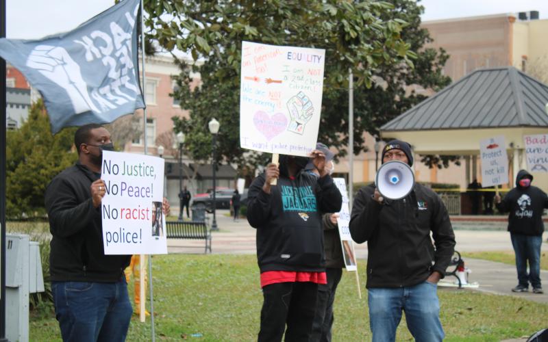 Sylvester Warren (right) uses a megaphone chanting 'No Justice, No peace; No racist police' during a Black Lives Matter protest where protesters we’re asking for police reform and better oversight. (TONY BRITT/Lake City Reporter)