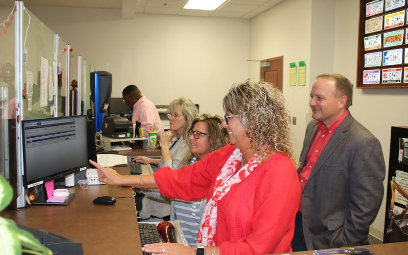 Sherrie Thomas (clockwise from left), Tracy Duckett, and Tammy Hartley, Columbia County Tax Collectors Office employees, show Kyle Keen, Columbia County tax collector, information on the new ORION software Tuesday afternoon. The tax collectors office will be closed Monday while employees take a day of in-service training to learn the new system. (TONY BRITT/Lake City Reporter)