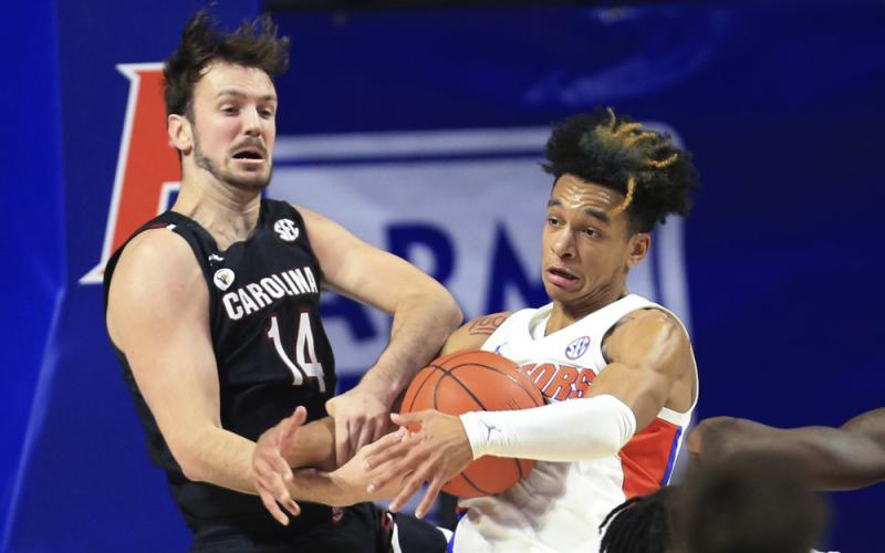 Florida guard Tre Mann, right, and South Carolina forward Nathan Nelson (14) struggle for a rebound on Feb. 3 in Gainesville. (MATT STAMEY/Associated Press)