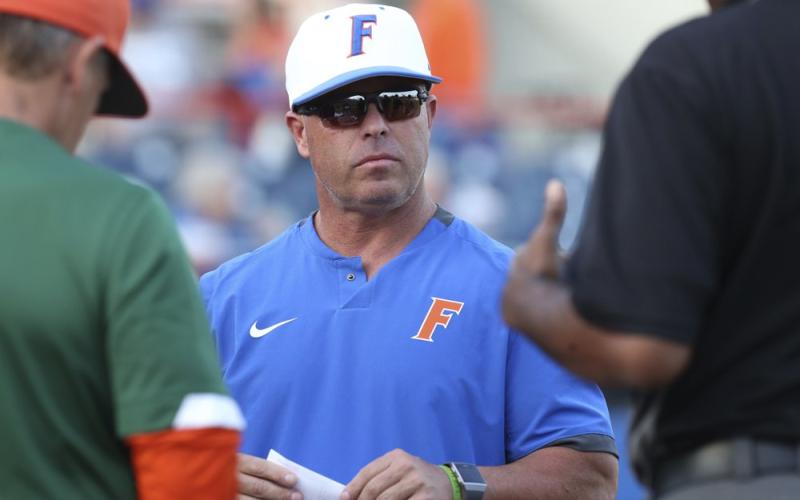 Florida coach Kevin O'Sullivan meets with umpires before his team’s game against Florida A&amp;M on March 4, 2020, in Gainesville. (AP FILE PHOTO)