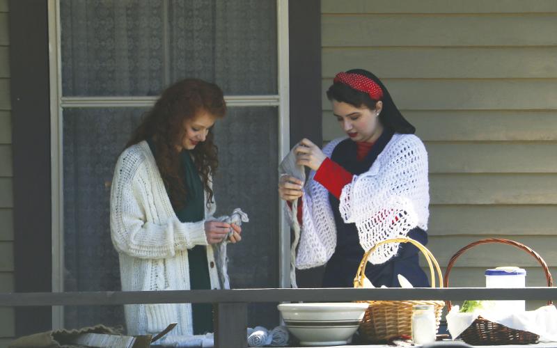 Zoe Elixson (from left) and Miracle Graham prepare bandages are part of their World War II display. (MORGAN MCMULLEN/Lake City Reporter)