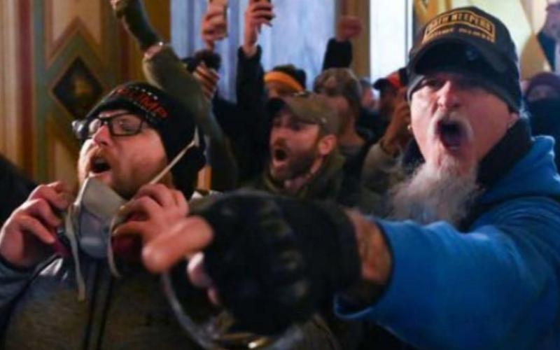 Indiana resident Jon Schaffer, right, is shown wearing a hat that says “Oath Keepers Lifetime Member” inside the U.S. Capitol Building during the Jan. 6, 2021, rioting, according to the FBI. He is now facing six federal criminal charges. (FBI/TNS)