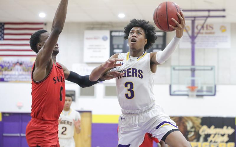 Columbia forward Charleston Ponds rises to the basket to shoot as Santa Fe center Ernest Ross defends during a game on Feb. 4. (BRENT KUYKENDALL/Lake City Reporter)