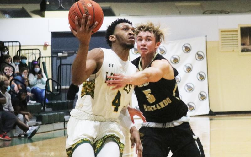 FGC guard Antonio Card rises on the fast break to score as PHSC guard Hayden Greene gives chase on Thursday night at the Howard Center. (JORDAN KROEGER/Lake City Reporter)