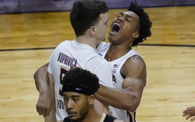 Florida State center Balsa Koprivica (5) gets a hug from teammate Scottie Barnes, right, after a dunk against Colorado in the second round of the NCAA Tournament at Farmers Coliseum on Monday in Indianapolis. (CHARLES REX ARBOGAST/Associated Press)