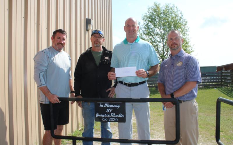 Andy Bennett (from left), Westside Elementary School physical education teacher; stands with Darryl Thomas, Columbia High School welding teacher; Dennis Dotson, Westside Elementary School principal; and Trey Hosford, Columbia High School principal; during a brief presentation Wednesday morning where the Grayson Martin Memorial Welding Scholarship was established at the Columbia High School welding lab. Martin was killed in a wreck weeks earlier. (TONY BRITT/Lake City Reporter)