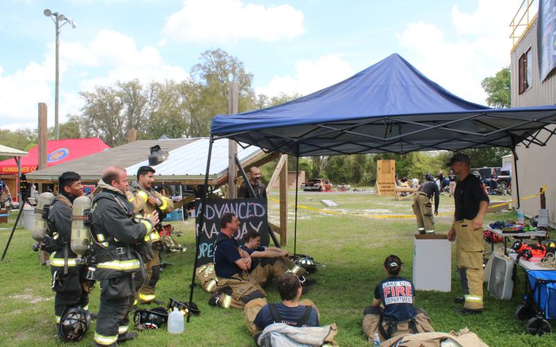 Firefighters adjust their gear as they listen to a Third Alarm Public Safety Training instructor present tips on firefighter survival. (TONY BRITT/Lake City Reporter)