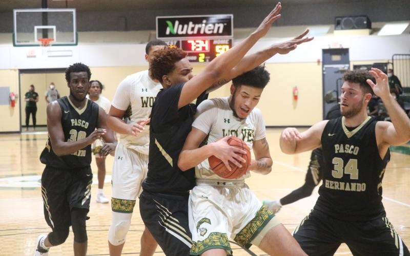 FGC forward Brandon Farmer gets double teamed by PHSC forwards Warren McLymont (left) and Edgard Enriquez (right) during Saturday's FCSAA Region 8 Division II Championship at the Howard Center. (JORDAN KROEGER/Lake City Reporter)
