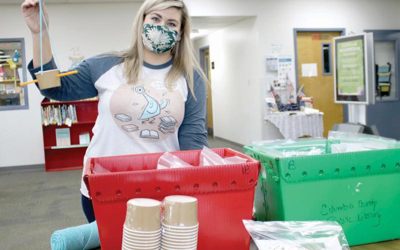 Kate Duong, the youth services librarian for the Columbia County Public Library, shows off the bird feeder students can make in the Backyard Birds kit. (TONY BRITT/Lake City Reporter)