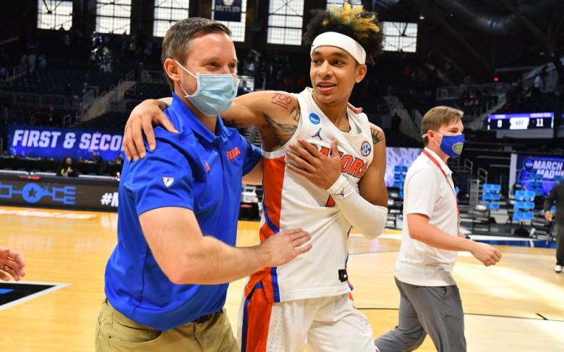 Florida head coach Mike White embraces Tre Mann after they defeated Virginia Tech in the first round of the NCAA Tournament at Hinkle Fieldhouse on March 19 in Indianapolis, Ind. (BRETT WILHELM/Pool Photo via AP)