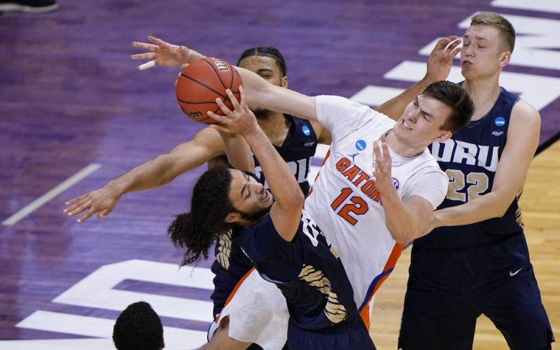 Oral Roberts guard Kareem Thompson, left, grabs a rebound in front of Florida forward Colin Castleton (12) during the second  round of the NCAA Tournament at Indiana Farmers Coliseum on Sunday in Indianapolis. (AJ MAST/Associated Press)