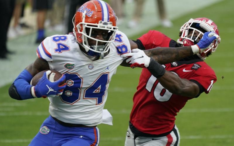 Florida tight end Kyle Pitts (84) tires to get past Georgia defensive back Lewis Cine (16) after a reception on Nov. 7, 2020, in Jacksonville. (AP PFILE PHOTO)