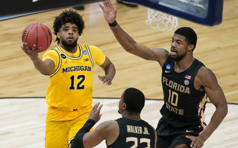 Michigan guard Mike Smith (12) drives to the basket over Florida State guard M.J. Walker (23) and forward Malik Osborne (10) during the second half of a Sweet 16 game in the NCAA Tournament at Bankers Life Fieldhouse on Sunday in Indianapolis. (DARRON CUMMINGS/Associated Press)