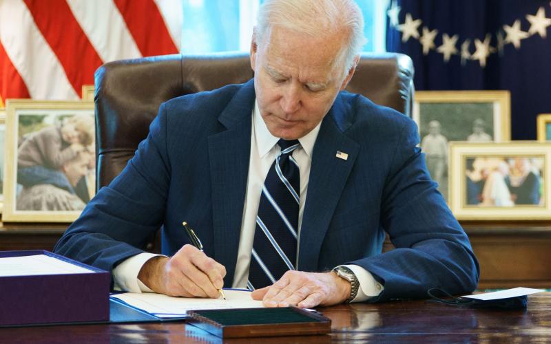 U.S. President Joe Biden signs the American Rescue Plan on Thursday in the Oval Office of the White House in Washington, D.C. (MANDEL NGAN/AFP/Getty Images/TNS)