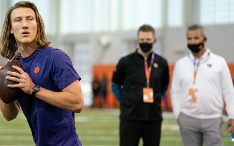 Clemson Tigers quarterback Trevor Lawrence works out as Jacksonville Jaguars head coach Urban Meyer (right) looks on during Clemson's Pro Day on Feb 12 in Clemson, S.C. (DAVID PLATT/Handout Photo via USA TODAY Sports via TNS)