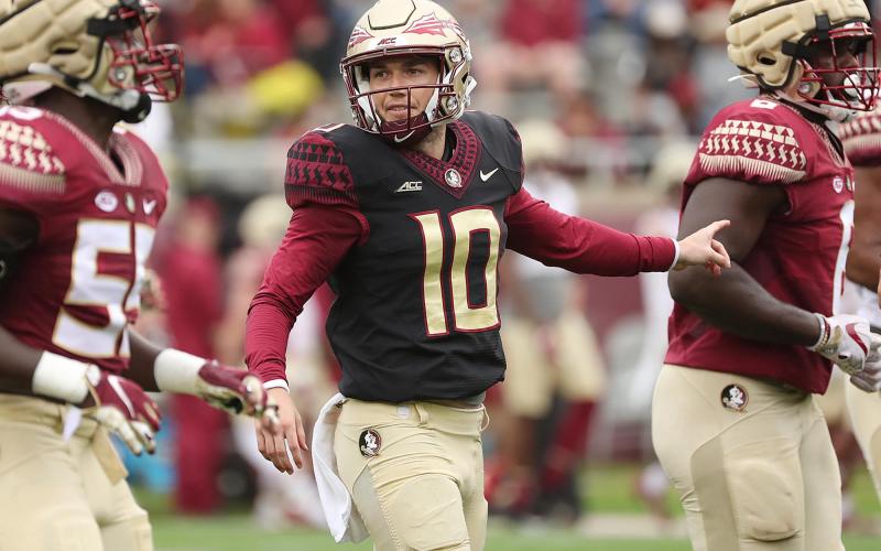 FSU quarterbacks Tate Rodemaker (18) and Gino English (15) watch quarterback McKenzie Milton (10) throw during the FSU Garnet &amp; Gold Spring Game at Doak Campbell Stadium on April 10 in Tallahassee. (STEPHEN M. DOWELL/Orlando Sentinel/TNS)