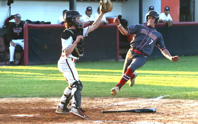 Fort White catcher Brad Sullivan (left) grabs a relay throw from right field but can’t apply the tag to a sliding Brantley Hengerer during the top of the third inning of the Indians’ 3-1 loss Monday night against Hilliard. (MORGAN MCMULLEN/Lake City Reporter)