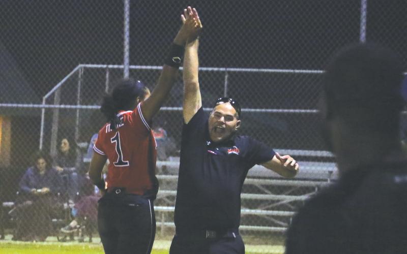 Fort White shortstop Ciara Byrd high fives assistant coach Chad Padgett after bringing in the winning runs against Madison County on Monday night. (MORGAN MCMULLEN/Lake City Reporter)