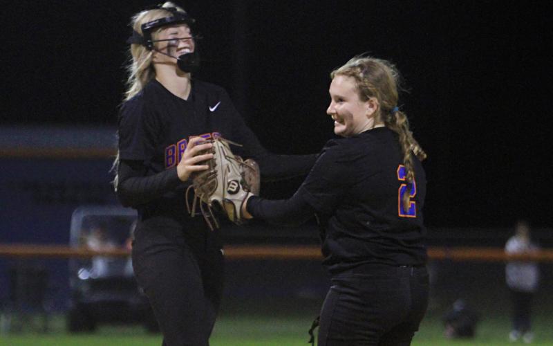 Branford third baseman Madison Sikes celebrates with pitcher Laila Arnold after an out against Fort White on Thursday night. (PAUL BUCHANAN/Special to the Reporter)