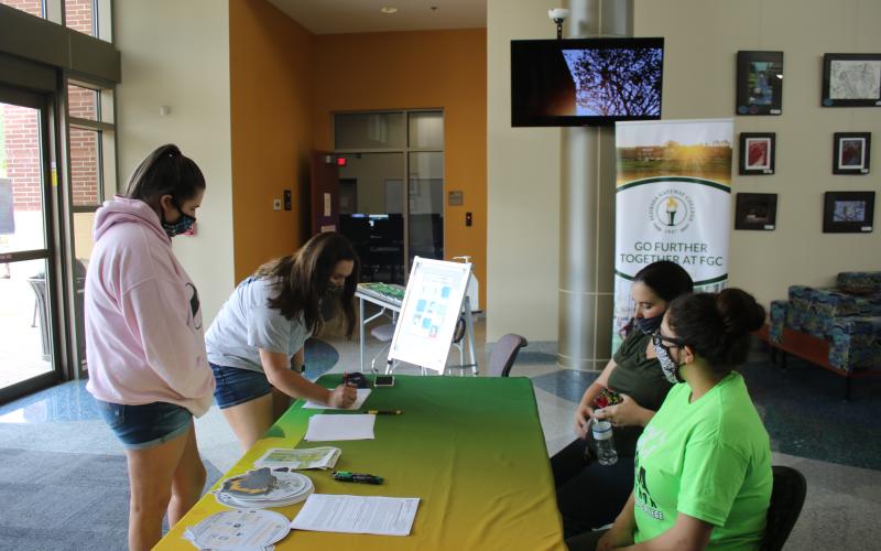 Jordan Brown (clockwise from left) looks on as Kailey Keen, signs up for FAFSA information with aid from Chelsea Allen and Meliza Acosta on Friday during Florida Gateway College’s FAFSA Marathon. (TONY BRITT/Lake City Reporter)