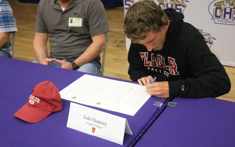 Columbia runner Cole Chancey signs his letter of intent to attend Flagler College on Wednesday. (JORDAN KROEGER/Lake City Reporter)