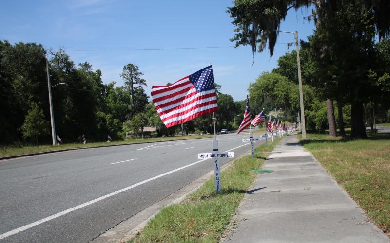 TONY BRITT/Lake City Reporter A row of flags — just several out of 114 — stand alongside State Road 47. Jack and Ann Hampton, along with a handful of volunteers, put them up on Saturday. (TONY BRITT/Lake City Reporter)