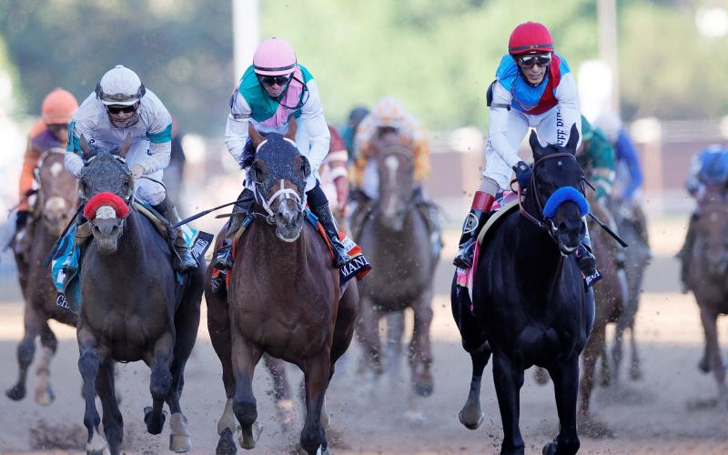 John Velazquez rides Medina Spirit ahead of Florent Geroux aboard Mandaloun and Flavien Prat aboard Hot Rod Charlie to win the 147th running of the Kentucky Derby at Churchill Downs on Saturday in Louisville, Ky. (SARAH STIER/Getty Images/TNS)