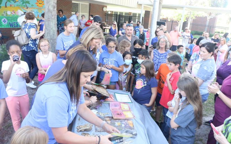 Contents from Westside Elementary's 20-year-old time capsule are laid out on a table Thursday afternoon. (MORGAN MCMULLEN/Lake City Reporter)