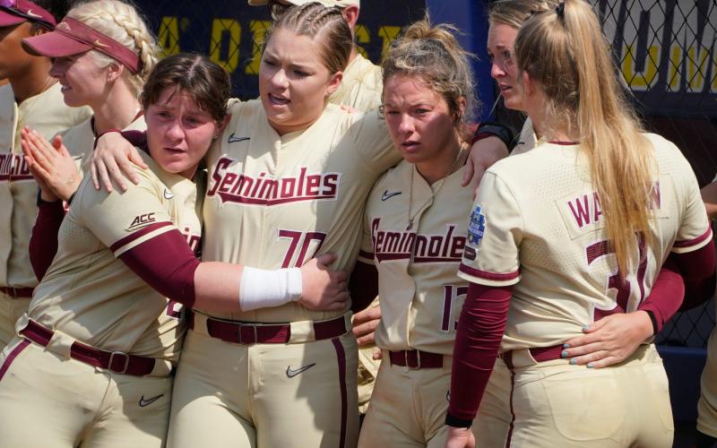 Florida State players Kaia LoPreste (from left), Cassidy Davis, Anna Shelnutt, Emma Wilson and Danielle Watson watch as Oklahoma players accept awards after they defeated Florida State in the final game of the Women's College World Series championship series Thursday in Oklahoma City. (SUE OGROCKI/Associated Press)
