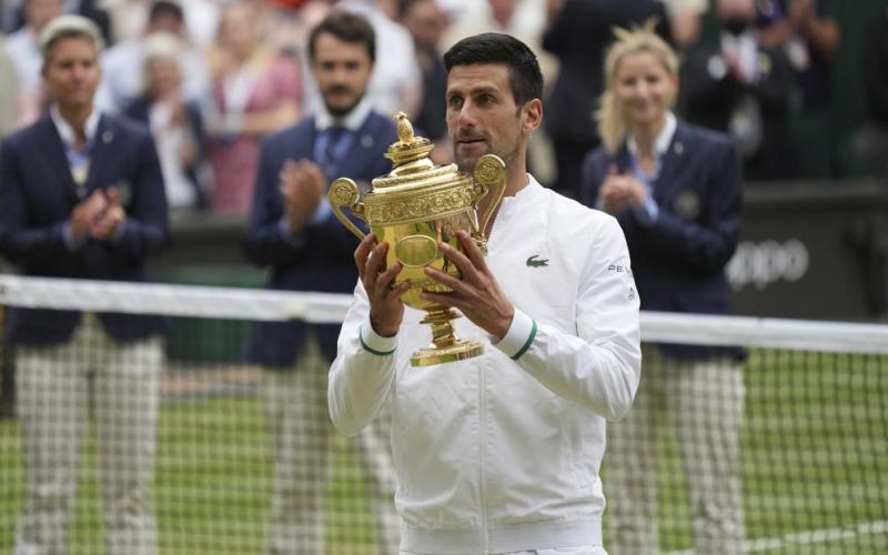 Novak Djokovic holds his winner's trophy and celebrates his victory over Matteo Berrettini in the Wimbledon men's singles final match on Sunday in London. (ALBERTO PEZZALI/Associated Press)