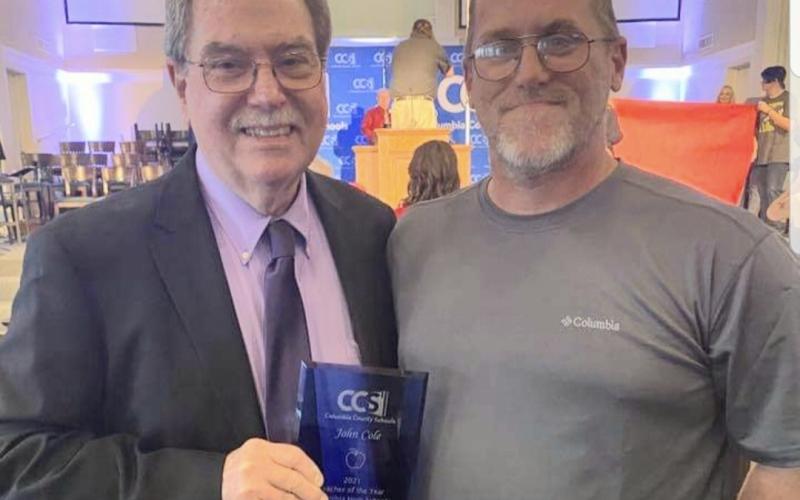 John Cole III (right) poses with his father after John Cole Jr. won the 2021 CCS Teacher of the Year award. (COURTESY)