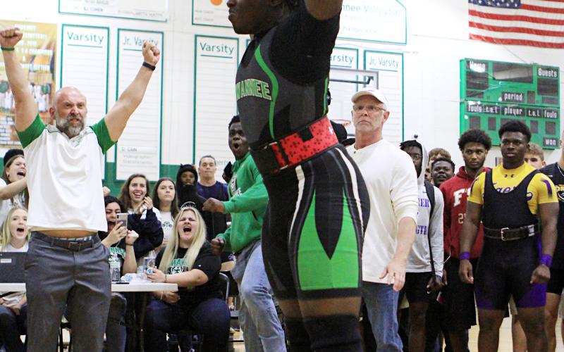 SHS weightlifting coach Dan Marsee (left) raises his fists in celebration after Austin Smith completes a rep. (PAUL BUCHANON/Lake City Reporter)