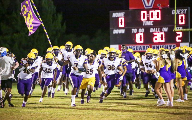 Columbia defensive end Adeon Farmer raises the team flag as he leads the Tigers onto the field prior to their Preseason Classic against Vanguard on Aug. 20. (BRENT KUYKENDALL/Lake City Reporter)