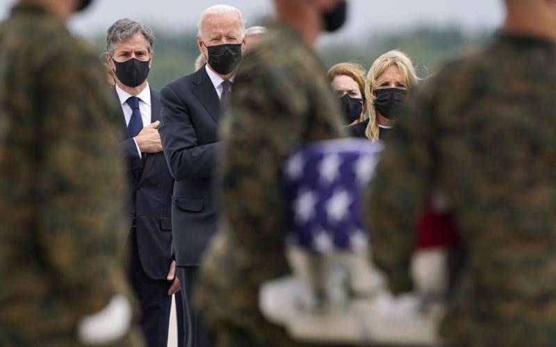 President Joe Biden, first lady Jill Biden, and Secretary of State Antony Blinken look on as as a carry team moves a transfer case with the remains of Marine Corps Cpl. Humberto A. Sanchez, 22, of Logansport, Ind., during a casualty return at Dover Air Force Base on Sunday for the 13 service members killed in the suicide bombing in Kabul on Aug. 26. (CAROLYN KASTER/Associated Press)