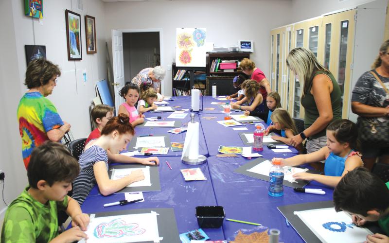 A group of students work on artwork Friday at the Gateway Art Gallery. Local artists served as instructors for the classes. (TONY BRITT/Lake City Reporter)