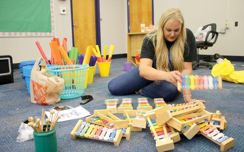 Dianna Swisher, the Columbia County School District’s volunteer and marketing coordinator, sorts through xylophones for Ginger Norris’s renovated music room at Fort White Elementary School. (TONY BRITT/Lake City Reporter)