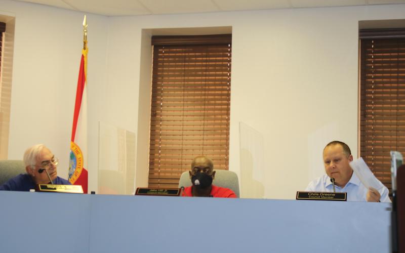 Lake City Council member Chris Greene holds a copy of his notice of proposed tax bill up during the council’s meeting Tuesday. (TONY BRITT/Lake City Reporter)