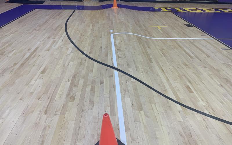 A stretch of Columbia’s gym floor is shown with a bump in it due to water damage. The school began tearing up the court on Tuesday to install a new one. (COURTESY)
