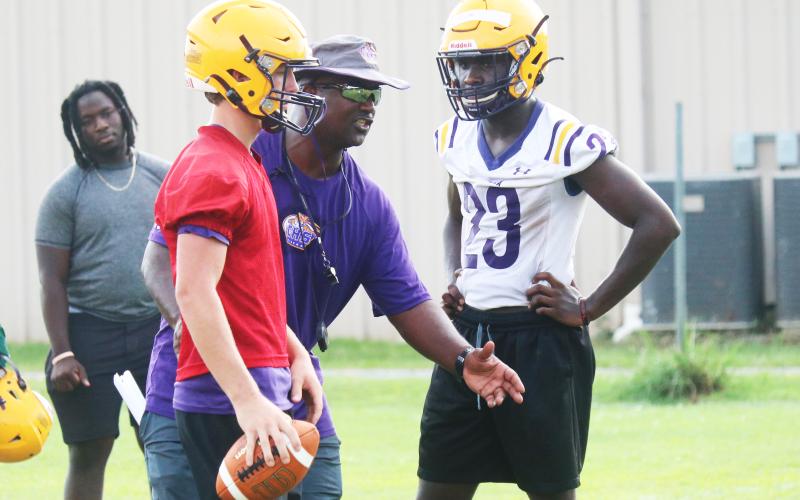Columbia head coach Demetric Jackson (middle) instructs quarterback Kade Jackson (left) and running back Malik Moore (right) during practice on Monday. (JORDAN KROEGER/Lake City Reporter)