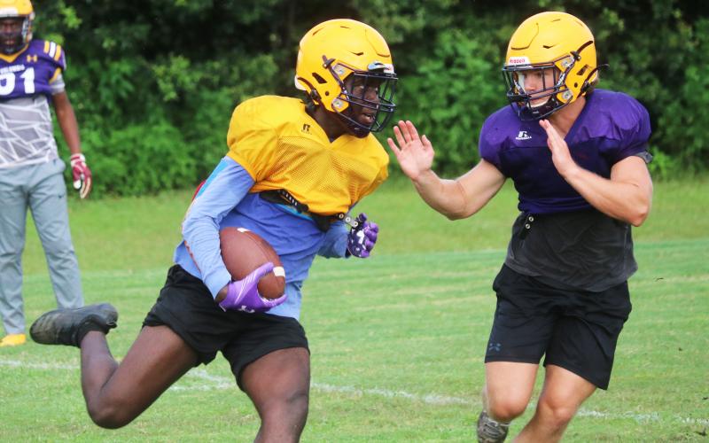Columbia receiver Brae Deal runs up the field after a catch as linebacker Noah Morris rushes in to tag him during practice on Friday. (JORDAN KROEGER/Lake City Reporter)