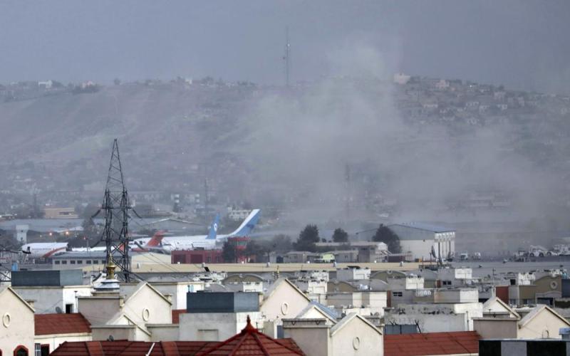 Smoke rises from a deadly explosion outside the airport in Kabul on Thursday. Two suicide bombers and gunmen targeted crowds massing near the Kabul airport. (WALI SABAWOON/Associated Press)