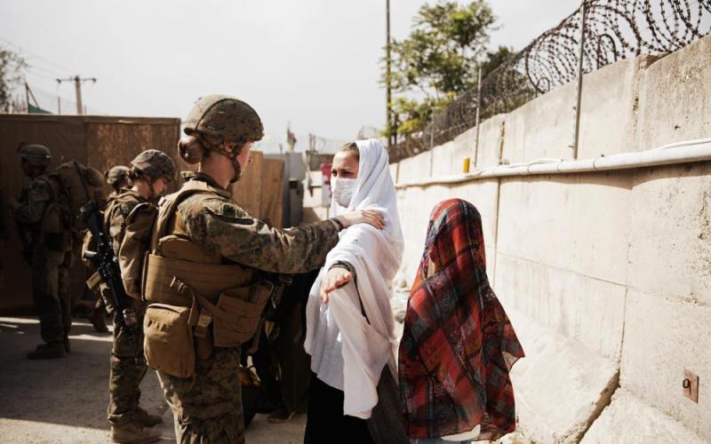 In this photo provided by the U.S. Marine Corps, two civilians during processing through an Evacuee Control Checkpoint during an evacuation at Hamid Karzai International Airport on Thursday in Kabul, Afghanistan. (STAFF SGT. VICTOR MANCILLA/U.S. Marine Corps via AP)