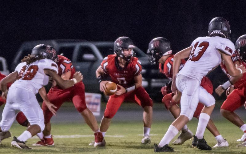 Fort White quarterback Clayton Philpot turns to hand the ball off against Middleburg during the teams’ Preseason Classic on Aug. 20. (CHRISTINA FEAGIN/Special to the Reporter)