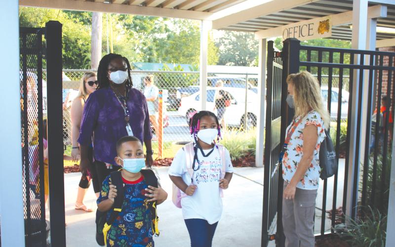 Jeanette Young (far right), an Eastside Elementary School employee, welcomes kindergartners and their parents to campus for the first day of school. (TONY BRITT/Lake City Reporter)