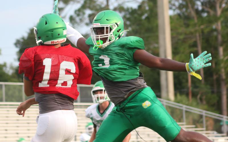 Suwannee defensive lineman Austin Smith tries to swat a pass from quarterback Bronsen Tillotson during a team scrimmage on Saturday. (JAMIE WACHTER/Lake City Reporter)