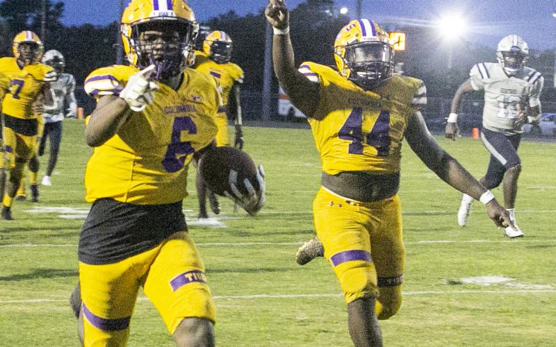 Columbia kick return Tray Tolliver points to the end zone as defensive end Bobby Miller celebrates alongside him during one of Tolliver's two punt returns for touchdowns against American Heritage-Delray on Friday night. (JEN CHASTEEN/Special to the Reporter)
